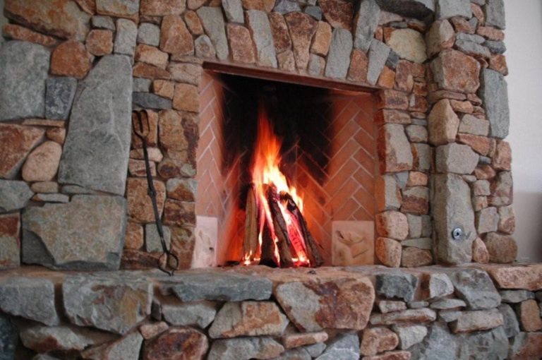 Rustic stone fireplace with a lit fire